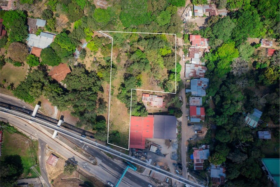 Vista aérea del terreno Cáceres en Arraiján, con su perímetro delimitado, frente a la Vía Panamericana y el viaducto de la Línea 3 del Metro